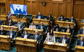 Ukrainian President Volodymyr Zelensky listens to Prime Minister Jacinda Ardern's response to his address to the New Zealand House of Representatives.