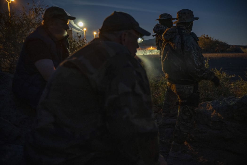 (FILES) In this file photo taken on March 20, 2019 (L-R) Jeff Allen, Jim Benvie, Viper and Stinger share cigarettes while patrolling the US-Mexico border in Sunland Park, New Mexico on March 20, 2019.