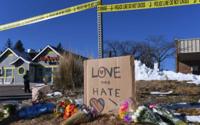 (FILES) Bouquets of flowers and a sign reading "Love Over Hate" are left near Club Q, an LGBTQ nightclub in Colorado Springs, Colorado, on November 20, 2022. A 23-year-old who shot five people dead at an LGBTQ club in the US state of Colorado last year pleaded guilty on June 26, 2023 and will face life in prison. (Photo by Jason Connolly / AFP)