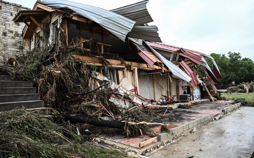 A damaged home is seen near Camp Mystic, the site of where at least 20 girls went missing after flash flooding in Hunt, Texas, on July 5, 2025. Rescuers were on Saturday searching for more than 20 girls missing from a riverside summer camp in the US state of Texas, after torrential rains caused devastating flooding that killed at least 27 people -- with more rain on the way. "So far, we've evacuated over 850 uninjured people, eight injured people and have recovered 27 deceased fatalities at this time. Of these 27, 18 are adults, nine are children," said Kerr Country Sheriff Larry Leitha on July 5. (Photo by RONALDO SCHEMIDT / AFP)