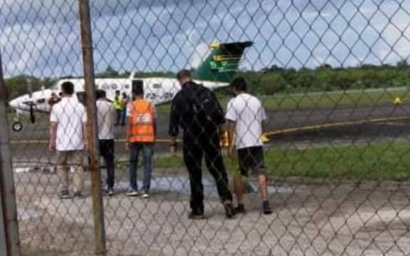 The three refugees are led to the plane at Manus Island airport.