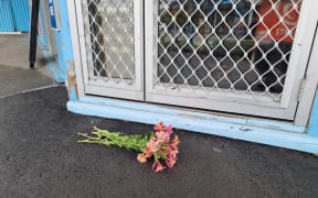 Flowers outside the Opawa Discounter, where the business' owner was stabbed during a robbery on 2 December.
