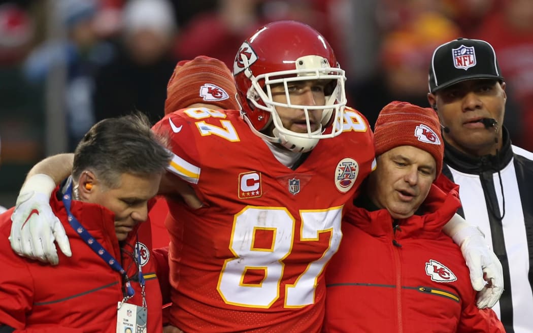 An NFL player is helped form the field after being concussed.