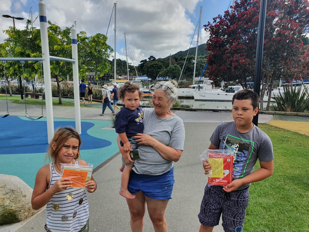 Donna with her grandchildren who have found something to read at a Whangārei playground.
