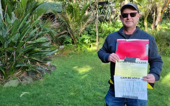 Duncan Leach holds some council safety notices.