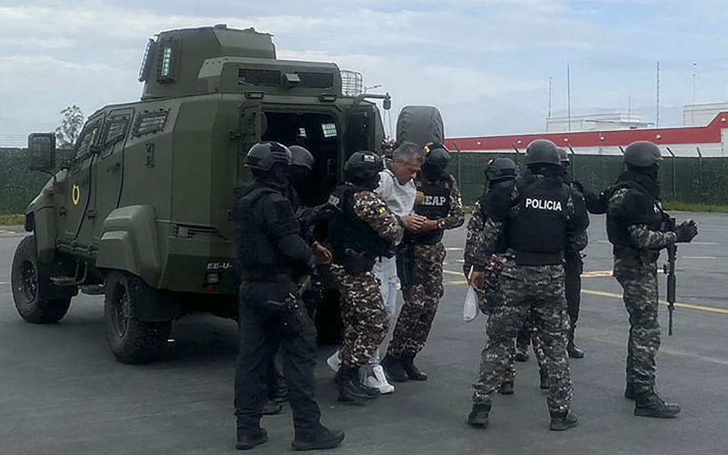 Former Ecuadorian vice president Jorge Glas, centre, is escorted by police prior to his transfer to the maximum security prison La Roca in Guayaquil on 6 April 2024. (Photo by Handout / Ecuadorian Police / AFP)