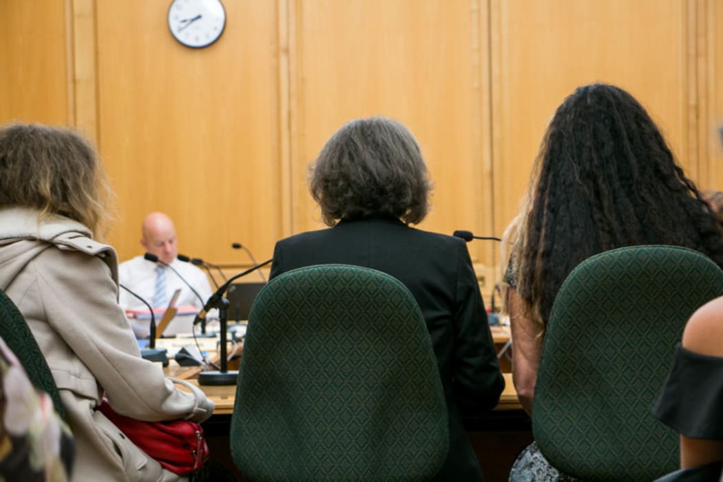 Maggie Wilkinson (center) gives her submission to Parliament on her petition calling for an inquiry into forced adoption in New Zealand between the 1950s and 1980s with her daughters either side.