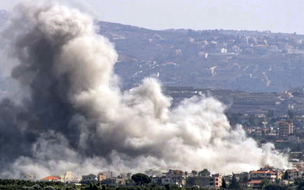 This picture taken from Lebanon's southern city of Tyre shows a cloud of smoke erupting following an Israeli air strike on the village of Deir Qanoun on October 14, 2024. - Israel expanded operations in Lebanon nearly a year after Hezbollah began exchanging fire in support of its ally, Hamas, following the Palestinian group's deadly attack on Israel on October 7, 2023. (Photo by Kawnat HAJU / AFP)