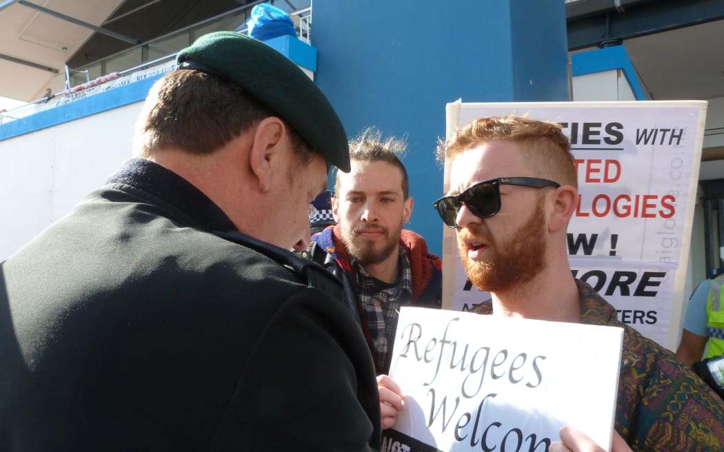 A protester stops a Defence Force member getting into the forum.