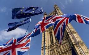 (FILES) In this file photo taken on March 28, 2019 Union and EU fags flutter outside the Houses of Parliament in Westminster, London.