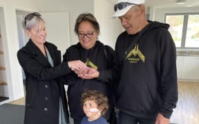 Lena and William Bennett, with grandson Charlie-James Pihama, receive their keys from their housing support manager Nicole Totoro, after living in a Bach for two years.