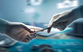 healthcare and medical concept , Close-up of surgeons hands holding surgical scissors and passing surgical equipment , motion blur background.