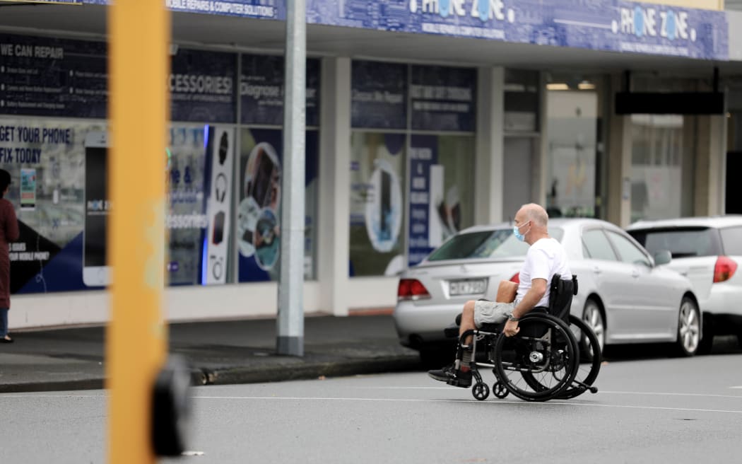 A man crosses the road in the wheelchair.