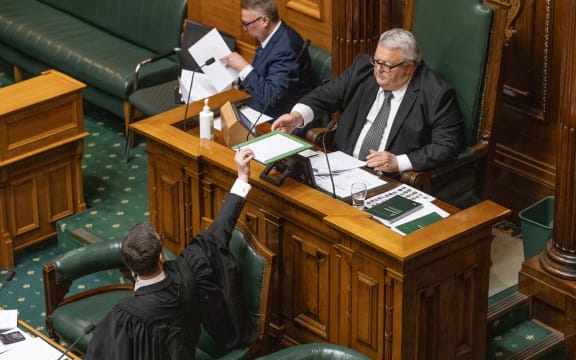 Parliament's Speaker, Gerry Brownlee, is handed the vote tally by the clerk on duty at the Table.