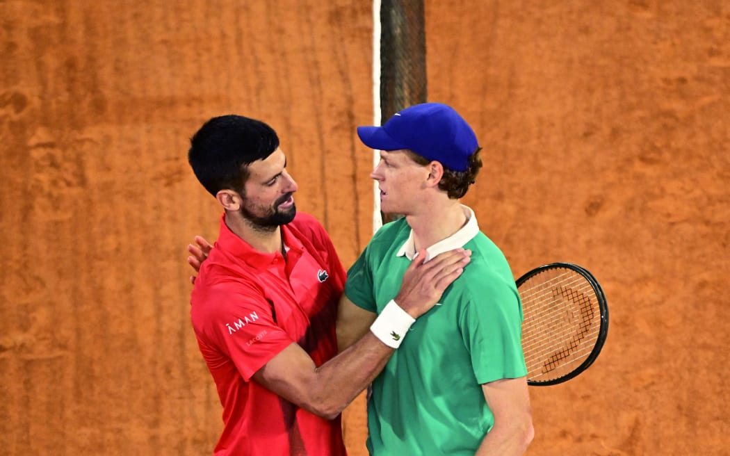 Winner Italy's Jannik Sinner cheers Serbia's Novak Djokovic (L) at the end of their men's singles semi-final match on day 13 of the French Open tennis tournament on Court Philippe-Chatrier at the Roland-Garros Complex in Paris on June 6, 2025. (Photo by JULIEN DE ROSA / AFP)