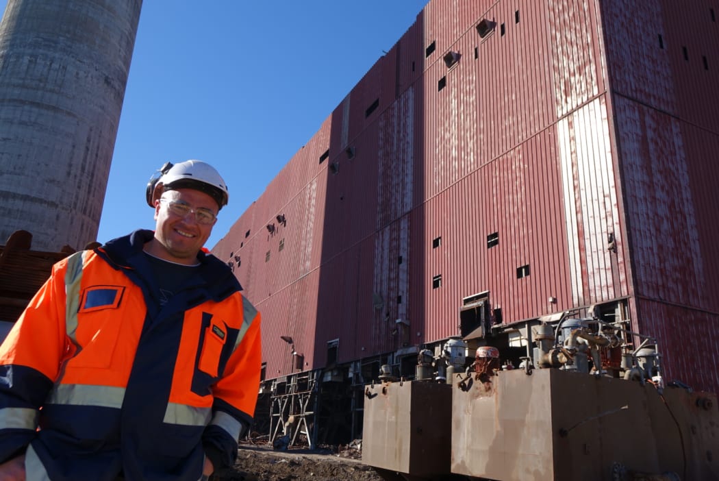 Nikau Contractors project manager John Paul Stil beside the New Plymouth Power Station boiler house which is to be completely demolished and the chimney that will remain standing.