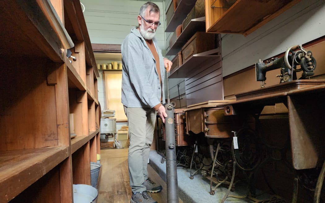 Bruce Laurence using an antique vacuum cleaner