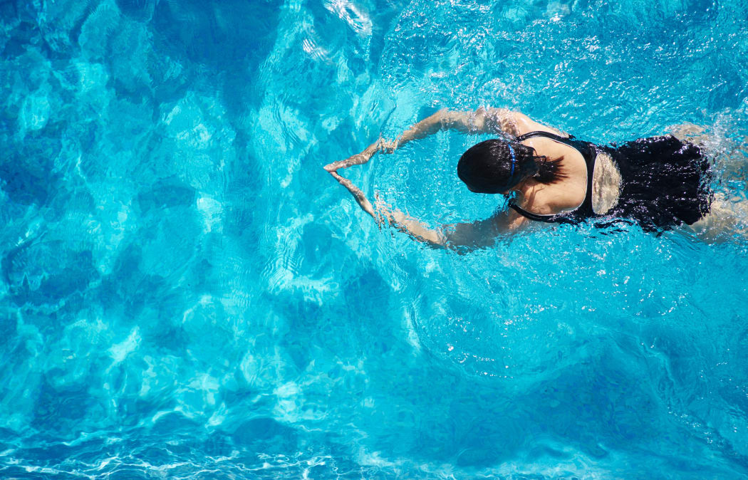 Overhead view of mature woman  swimming in swimming pool (Photo by Matt Lincoln / Cultura Creative / Cultura Creative via AFP)