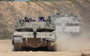 An Israeli soldier operates a tank at a position along Israel's southern border with the northern Gaza Strip on March 19, 2025. Israel on March 18 launched its most intense strikes on the Gaza Strip since a January 19 ceasefire with Palestinian militant group Hamas ended more than 15 months of war. (Photo by Jack GUEZ / AFP)