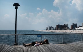 A woman lays along the boardwalk at Coney Island on a hot summer afternoon on August 7, 2018 in New York City.