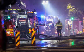 Firemen work at the scene of a fire at a building in Sydney on May 25, 2023. More than 100 firefighters battled towering flames and thick smoke from a seven-storey blaze in central Sydney on May 25, warning that it is spreading to other buildings. (Photo by DAVID GRAY / AFP)