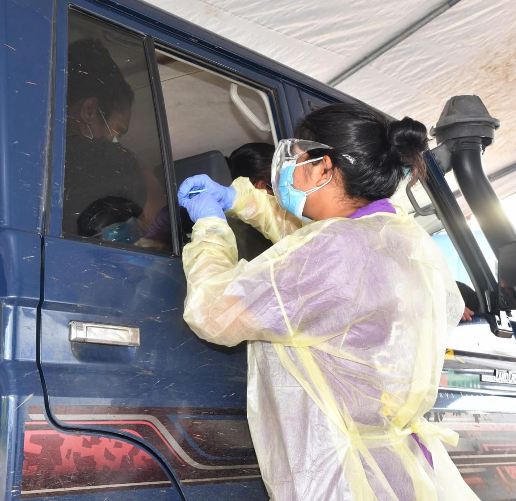 Medical worker in Fiji administering a  vaccination.