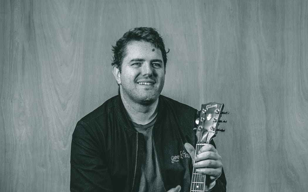 Image of Andy Christiansen holding a guitar.