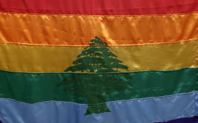 A gay pride flag bearing the cedar tree of the Lebanese flag carried by a human rights activists during an anti-homophobia rally in Beirut in 2013.