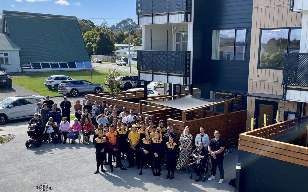 Kaikarakia Morehu Pewhairangi (far right) standing alongside Te Kura Kaupapa Māori o Hawaiki Hou students (in yellow), who helped assist him in leading karakia for the new Kāinga Ora development on the corner of Roebuck Rd and Norman Rd on Monday Morning. Attendees included new tenants, Kura staff, Kāinga Ora and its partners.