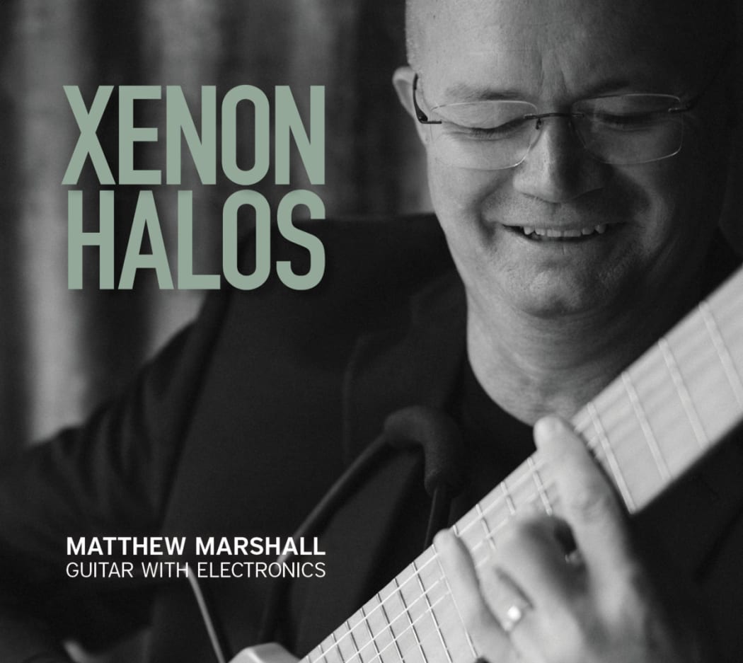Matthew Marshall plays his classical guitar on the black and white cover of his new album, Xenon Halos.