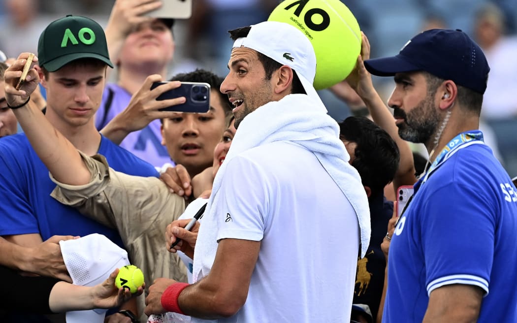 Serbia's Novak Djokovic signs autographs to fans after a practice session on day two of the Australian Open tennis tournament in Melbourne on January 17, 2023. (Photo by MANAN VATSYAYANA / AFP) / -- IMAGE RESTRICTED TO EDITORIAL USE - STRICTLY NO COMMERCIAL USE --