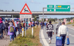 Refugees walking north along the Danish E45 motorway.