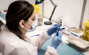 Medical personnel prepares a syringe for vaccination with the AstraZeneca vaccine at the Region Hovedstaden's vaccine center in Bella Center in Copenhagen on February 11, 2021, amid the ongoing coronavirus Covid-19 pandemic.