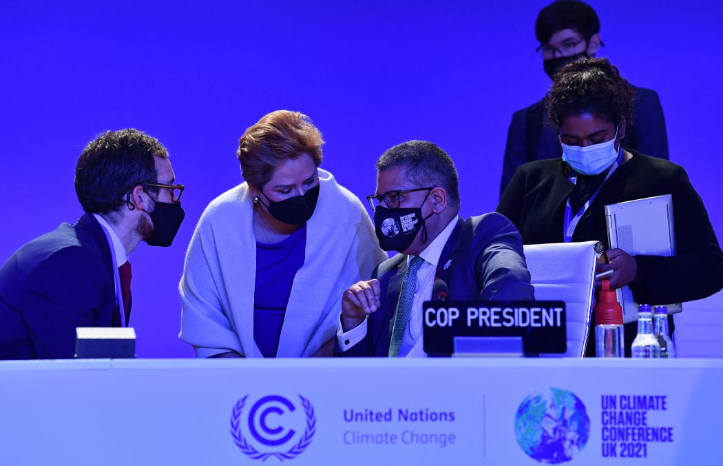 Britain's President for COP26 Alok Sharma speaks with UNFCCC Executive Secretary Patricia Espinosa and other members of his team following an informal stocktaking session at the COP26 Climate Change Conference in Glasgow on 12 November 2021.