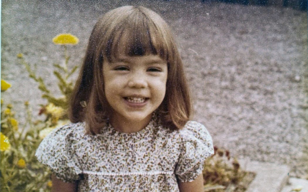 70's photo of young girl with a bob in a floral dress