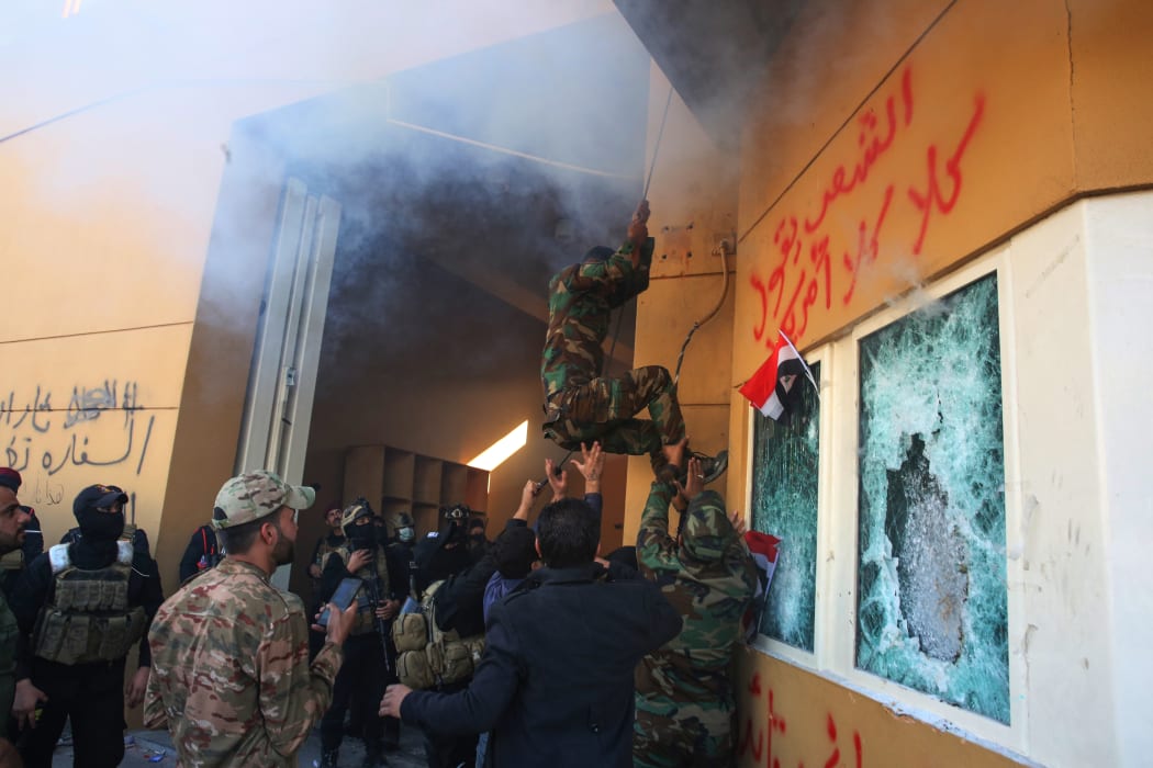 Members of Iraq's Hashed al-Shaabi military network attempt to break into the US embassy in the capital Baghdad, on December 31, 2019.
