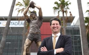 John Eales in front of the statue in his honour at Suncorp Stadium.