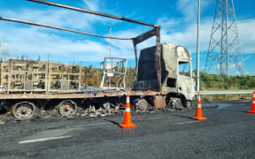 The burned wreckage of a truck that burst into flames on Auckland's southern motorway on 8 March 2023. The truck had been carrying canisters containing highly flammable gas.