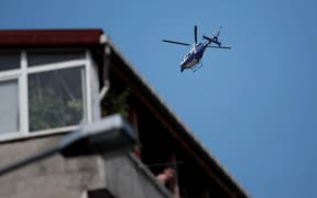 A police helicopter hovers during the funeral at Gazi Street in Istanbul for three of those killed in Suruc.