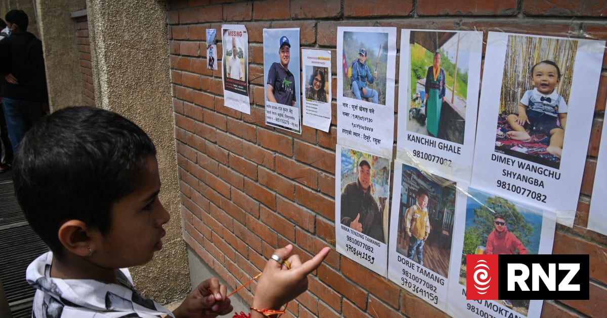 A child looks at the photographs of missing people following flash floods, at a hospital in Kathmandu on August 28, 2026