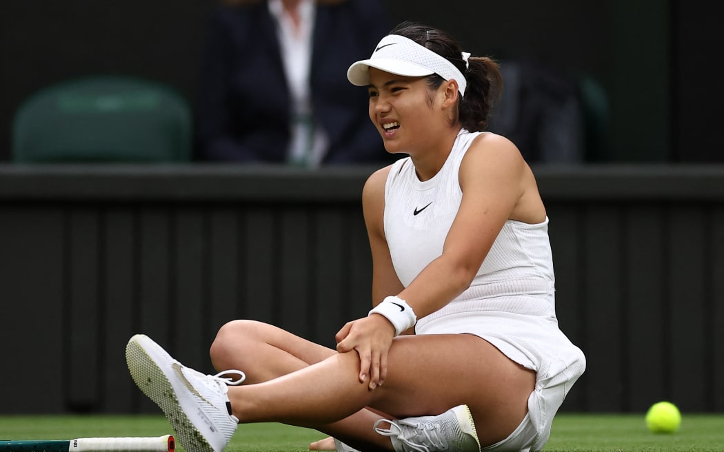 Britain's Emma Raducanu reacts after slipping on the court whilst trying to reach a ball from New Zealand's Lulu Sun during their fourth round match on the seventh day of the 2024 Wimbledon Championships at The All England Lawn Tennis and Croquet Club in Wimbledon, southwest London, on July 7, 2024.