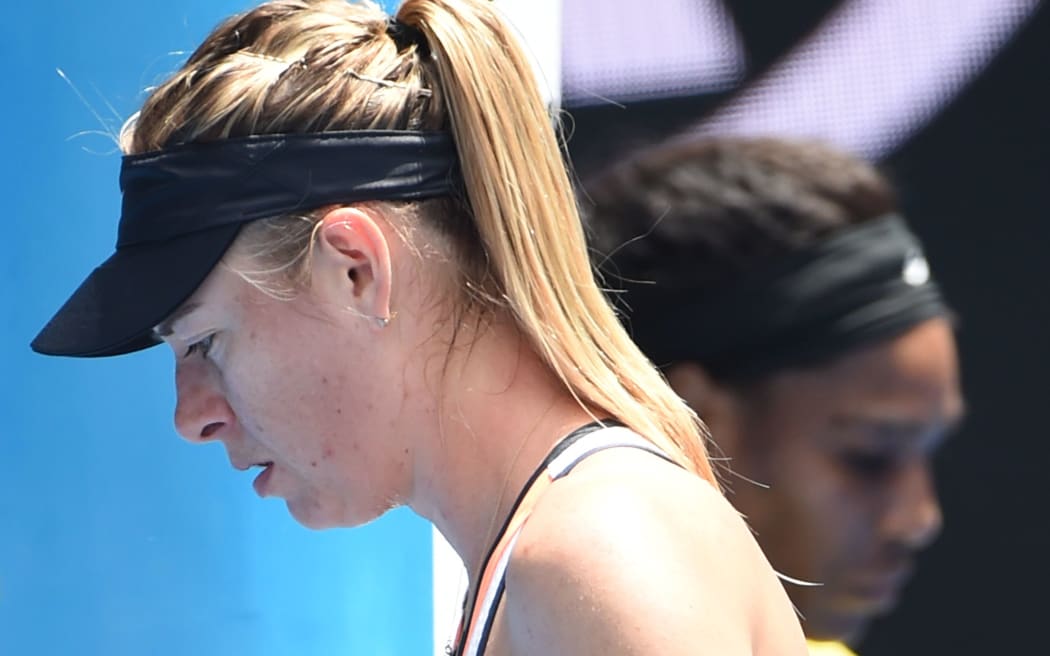 Russia's Maria Sharapova walks on court during a break in her match against Serena Williams of the US (R) on day nine of the 2016 Australian Open, January 26, 2016. AFP PHOTO / WILLIAM WEST