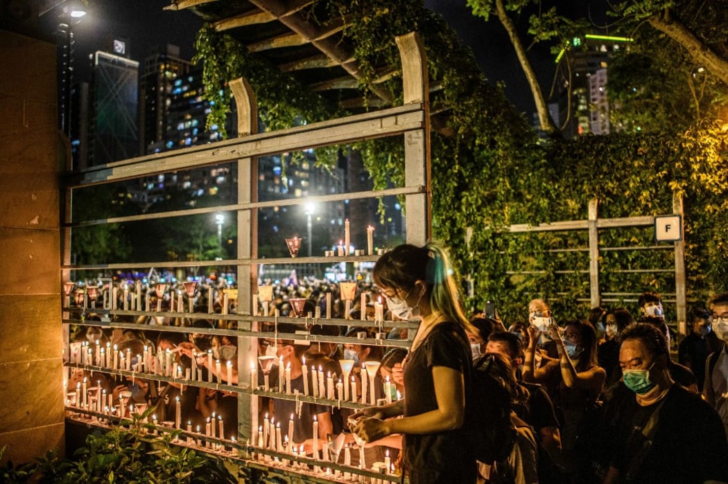 Tens of thousands of people across Hong Kong lit candles and chanted democracy slogans to commemorate China's deadly Tiananmen crackdown, defying a ban against gathering as tensions seethed over a planned new security law.