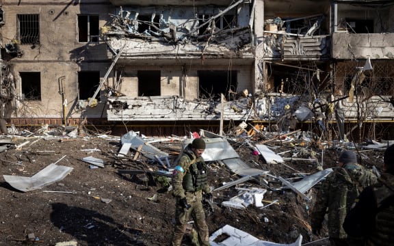 A Ukrainian soldier inspects the rubble of a destroyed apartment building in Kyiv on 15 March 2022.