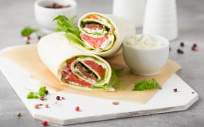 Tortilla with salmon, lettuce and cream cheese.