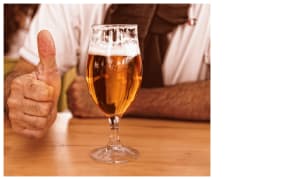 Glass of beer and hand showing a thumbs up sign