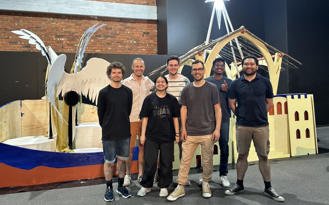 Photo of a portrait of 7 people standing in front of the nativity float.