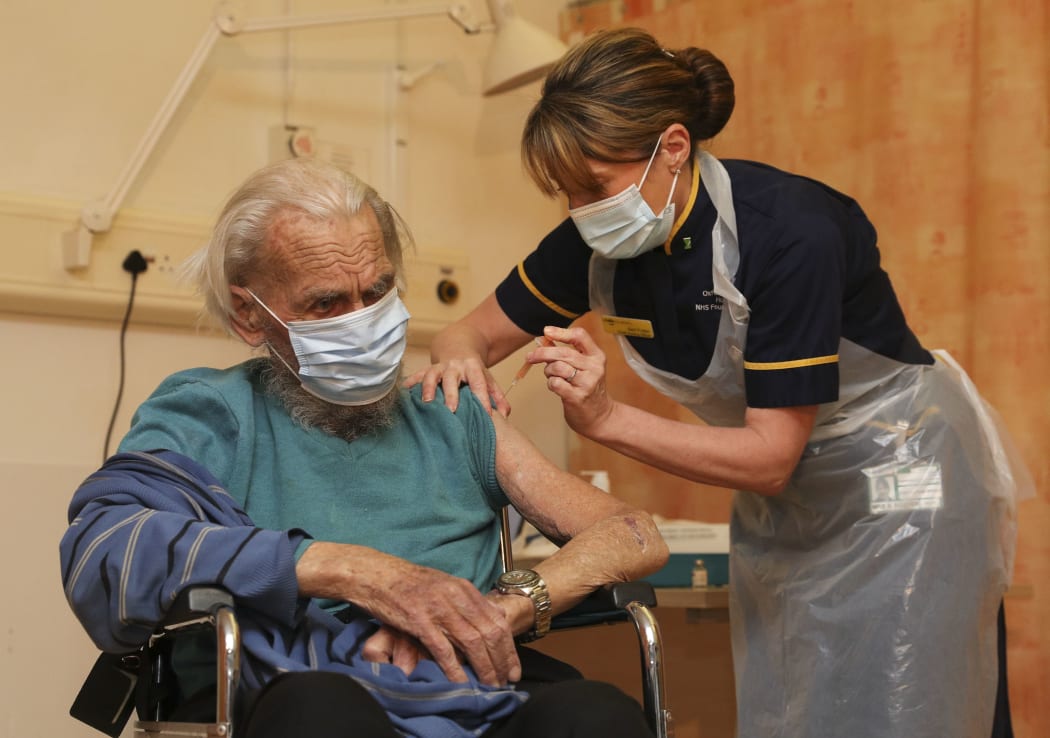 Trevor Cowlett, 88, receives the Oxford University/AstraZeneca Covid-19 vaccine from a nurse at the Churchill Hospital in Oxford, southwest England on January 4, 2021.