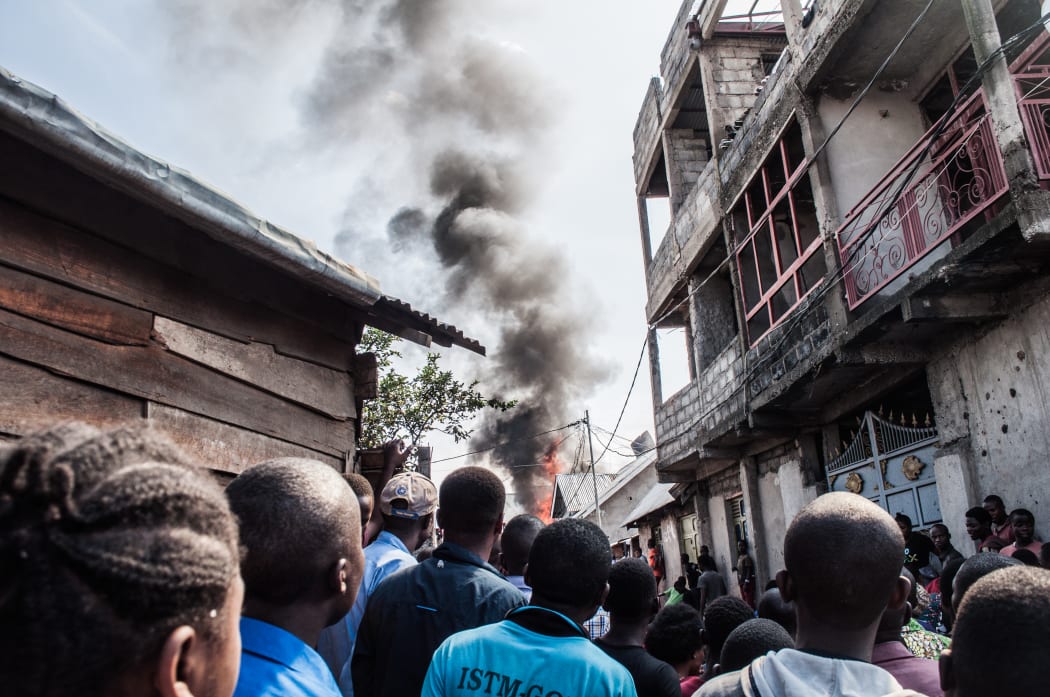 Residents react after a small aircraft carrying 18 people crashed in Goma on the East of the Democratic Republic of Congo on 24 November, 2019.