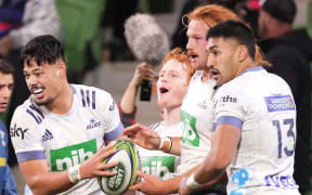 Tom Robinson of the Blues is congratulated by his teammates after scoring a try during the Round 1 Trans-Tasman Super Rugby match between the Melbourne Rebels and the Auckland Blues at AAMI Park in Melbourne, Saturday, May 15, 2021. (AAP Image/Scott Barbour) NO ARCHIVING, EDITORIAL USE ONLY